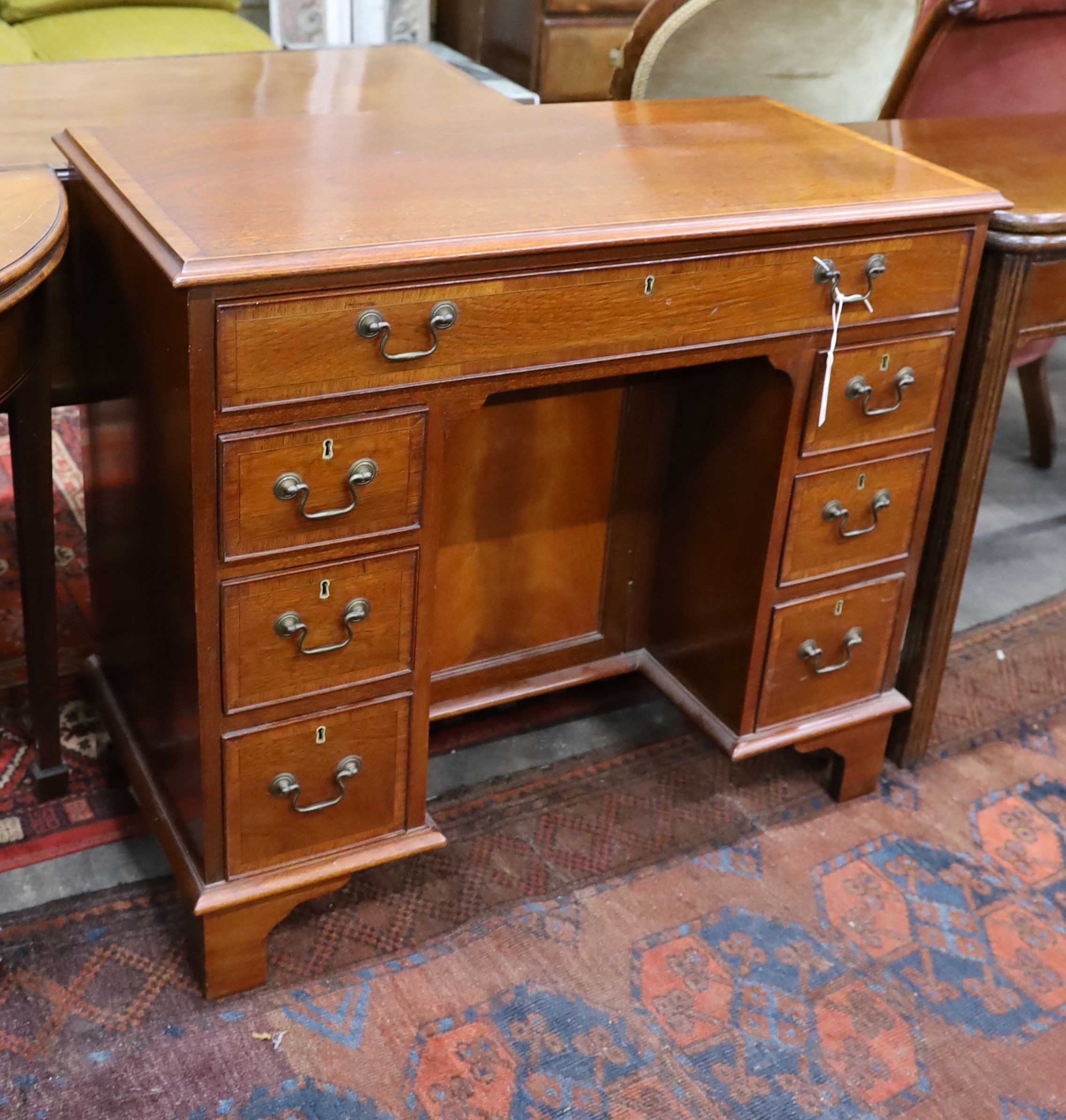 A reproduction George III style rosewood banded mahogany kneehole desk, length 88cm, depth 44cm, height 77cm